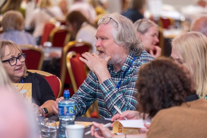 A group of people engaged in discussion at a conference table.